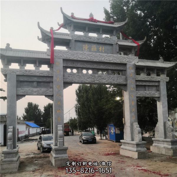 村莊入口擺放大型青石浮雕三門石牌坊雕塑