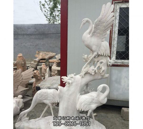 景區漢白玉石雕樹干上的鶴雕塑