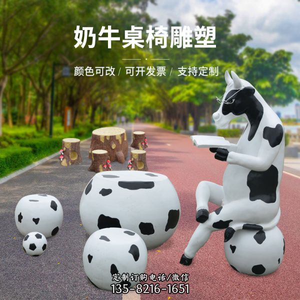 戶外園林中一只坐著看書的奶牛桌椅玻璃鋼牛雕塑