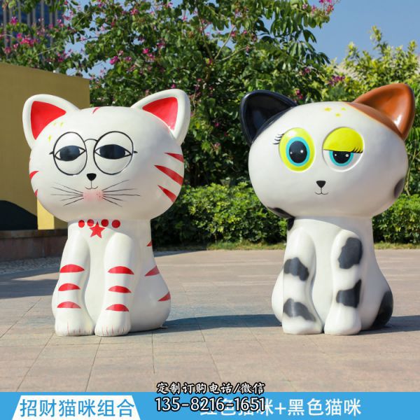 公園街道邊擺放著一只紅色的和一只黑色的玻璃鋼彩繪貓雕塑