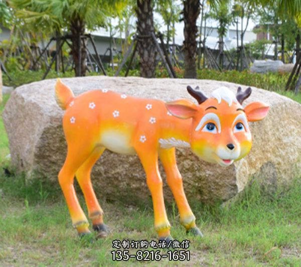公園草坪石頭旁邊的玻璃鋼鹿雕塑