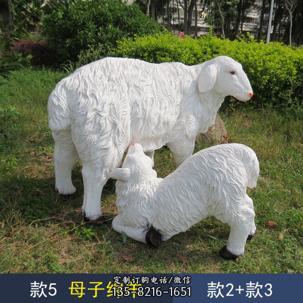 草地上擺放的喂奶的仿真玻璃鋼綿羊雕塑